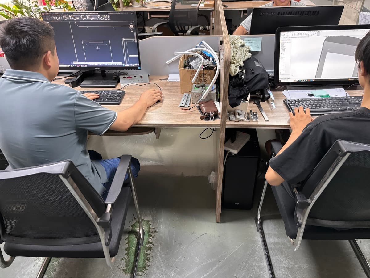 CRTLY structural engineers reviewing kiosk enclosure designs in CAD