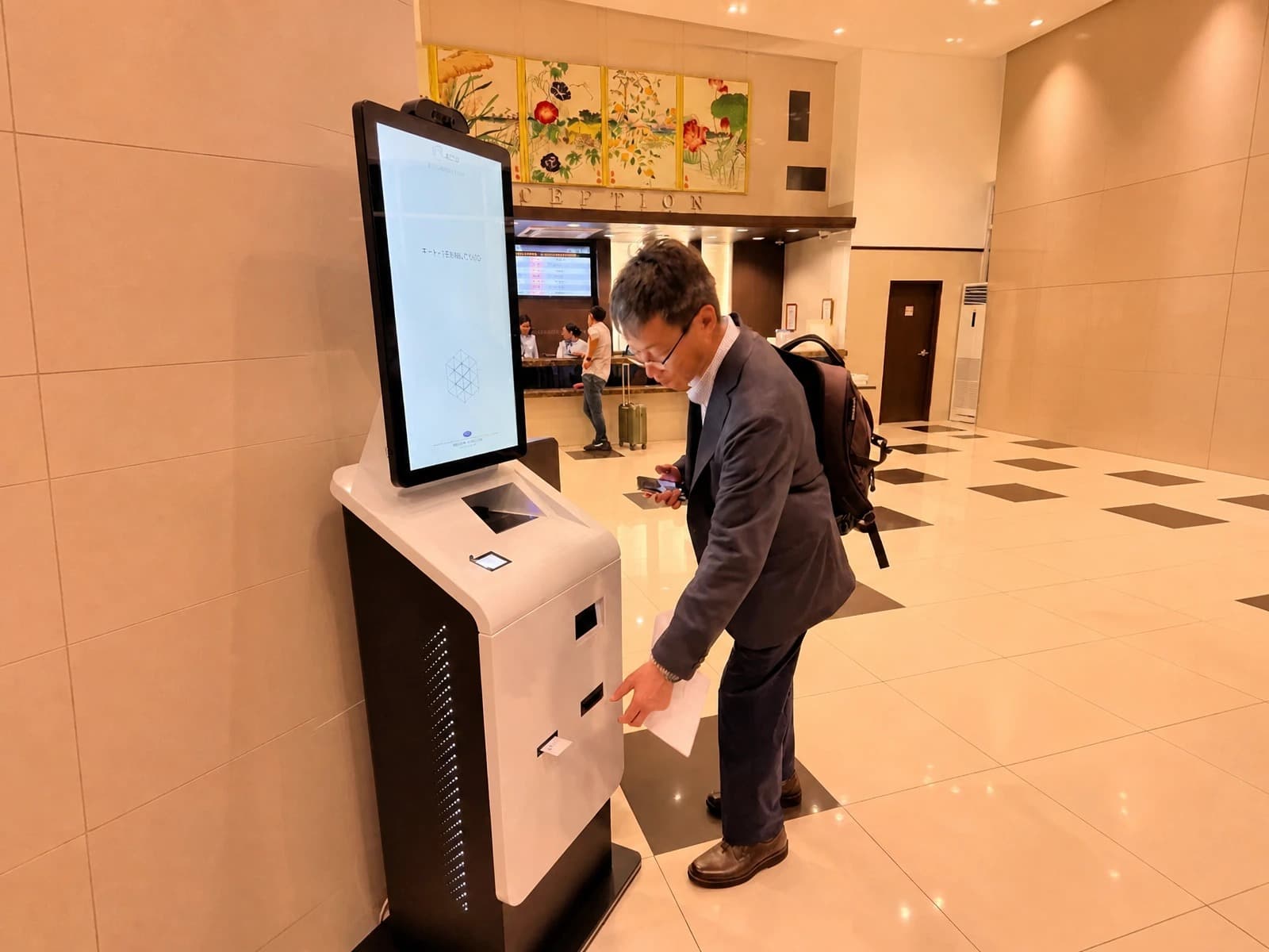 Hotel guest using a self-service kiosk for automated check-in or check-out